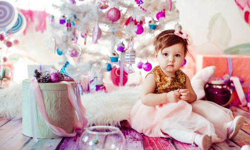 girl-golden-dress-sits-present-boxes-before-christmas-tree