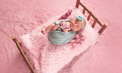 small-child-lies-bed-with-toys